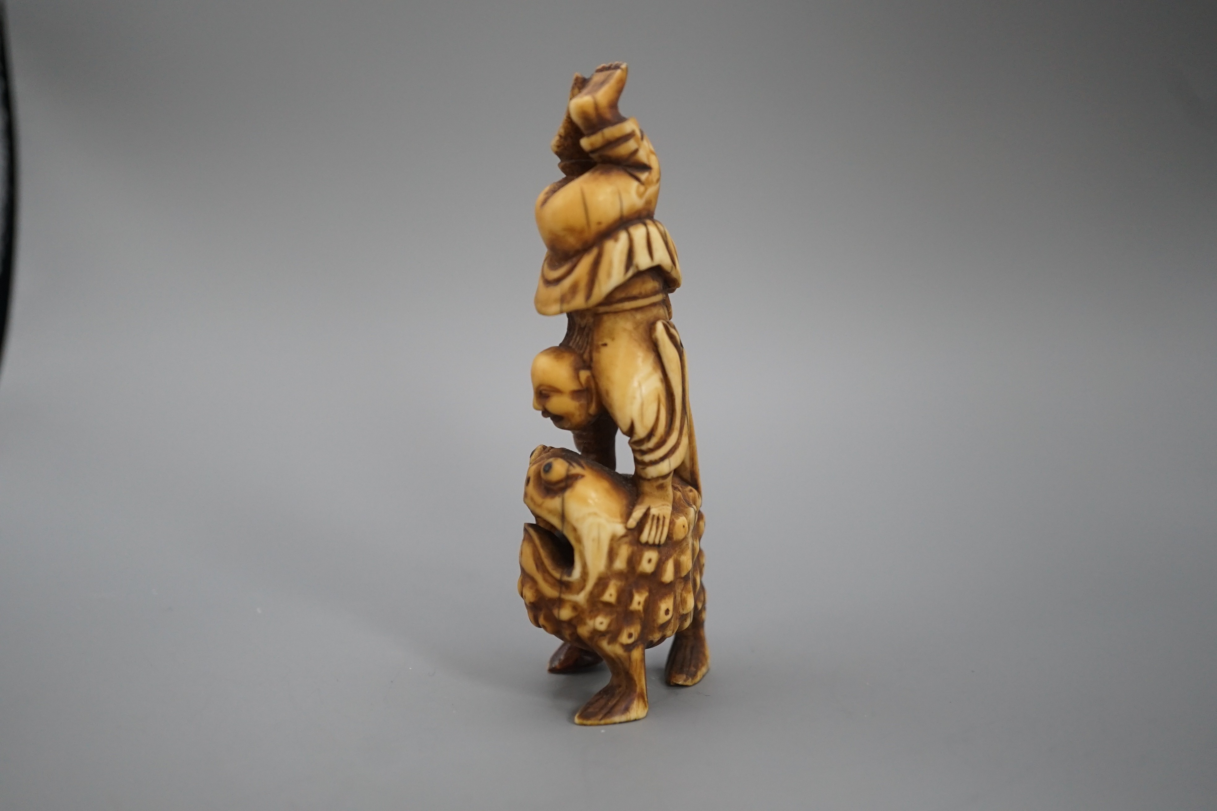 A 19th century Chinese or Japanese carved walrus ivory figure of Liu Hai balancing on his three legged toad, 9cm